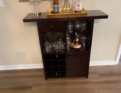 Dark wood bar cabinet with glass and bottle storage. The Villages Florida